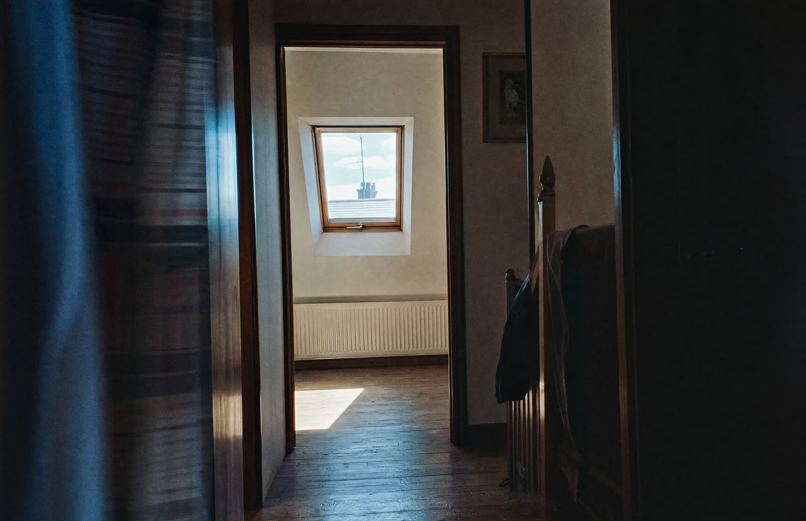 A sunlit room with a skylight, seen through the doorway of a quiet house.